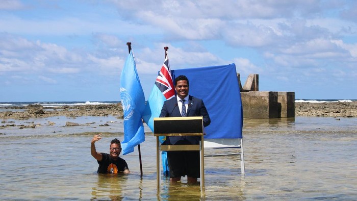 Menlu Tuvalu Simon Kofe Menteri Luar Negeri Tuvalu, Simon Kofe, memberikan pidato untuk Konferensi Perubahan Iklim (COP26) di pantai laut. Kofe berdiri menceburkan diri dengan lutut terendam air laut, sembari ditemani bendera Perserikatan Bangsa-Bangsa (PBB) dan bendera kebangsaan negara itu.