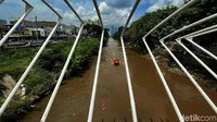 Petugas BPDB DKI Jakarta menyelusuri sungai Ciliwung dengan perahu karet.