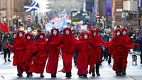 Juru kampanye dari kelompok Extinction Rebellion berjalan kaki di Glasgow, Skotlandia, (26/11/2021).  Pertemuan yang membahas perubahan iklim dihadiri sederet pemimpin negara, pengambil kebijakan pemerintah, ekonomi maupun sosial budaya. Orang-orang hebat dari 200 negara berkumpul di sini.  (AP Photo/Scott Heppell)