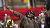 Juru kampanye dari Extinction Rebellion mengenakan kostum zombie saat mencari perhatian di  Georges Square, di saat berlangsungnya COP26 Climate Change, di Glasgow, Skotlandia (7/11/2021).  (AP Photo/Alastair Grant)