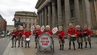 Pegiat dari aktivis Oxfam bermain teatrikal dengan topeng para pemimpin dunia yang tergabung menjadi sebuah band Hot Air Band di Glasgow, Skotlandia, (1/11/2021). Mereka beraksi di luar gedung tempat pertemuan konferensi perubahan iklim, COP26 Climate Change digelar. (AP Photo/Scott Heppell)