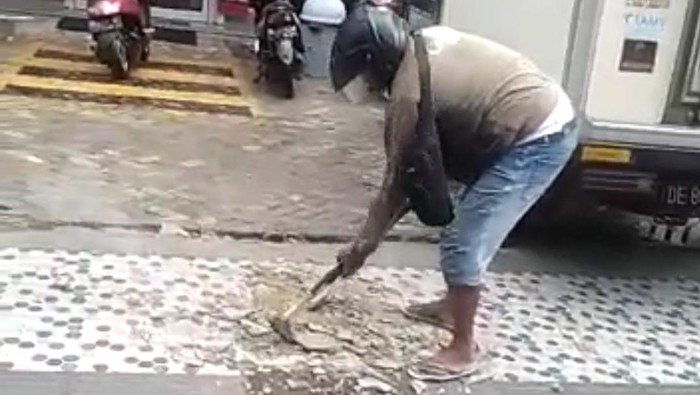 Tangkapan layar video viral pria di Ambon hancurkan trotoar gegara istri jatuh. (dok. Istimewa)