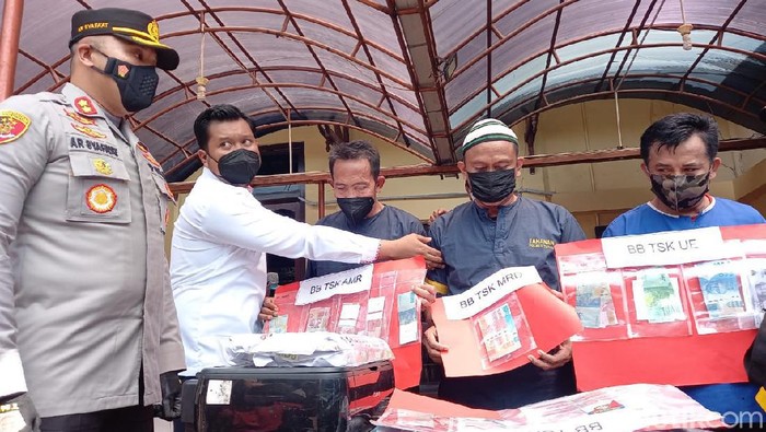 Tiga tersangka peredaran uang palsu di Tegal saat rilis di Polres Tegal. Salah satu tersangka merupakan mantan Kades Warureja, Amirudin (paling kiri).