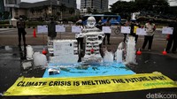 Dalam aksinya Greenpeace menyajikan patung yang terbuat dari balok es.