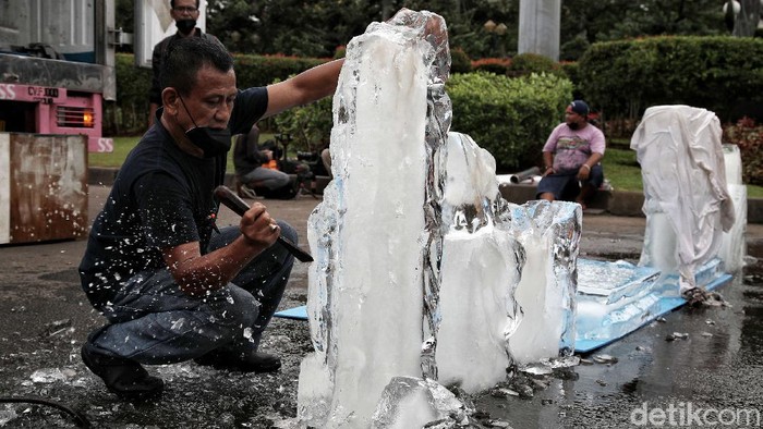 Aktivis Greenpeace menggelar aksi damai di Patung Kuda, Jakarta Pusat. Dalam aksi 1000 kartu pos dari rakyat untuk Jokowi itu, Greenpeace juga menghadirkan patung es.
