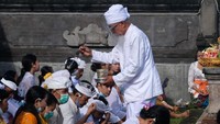 Pemuka Agama Hindu memercikkan air suci saat persembahyangan Hari Raya Galungan di Pura Puseh Desa Adat Kedisan, Jembrana, Bali. ANTARA FOTO/Nyoman Hendra Wibowo