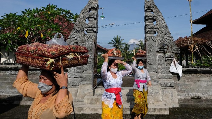 Umat Hindu melaksanakan persembahyangan Hari Raya Galungan di Pura Puseh Desa Adat Kedisan, Jembrana, Bali, Rabu (10/11/2021). Perayaan Hari Raya Galungan di pelosok Bali tersebut tetap menerapkan protokol kesehatan dan mengatur jumlah umat yang berada di area pura untuk mencegah penyebaran COVID-19. ANTARA FOTO/Nyoman Hendra Wibowo/aww.