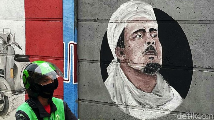 Persaudaraan Alumni (PA) 212 berencana menggelar Reuni 212 di Monas. Jelang reuni, mural bergambar Habib Rizieq Shihab mejeng di Pondok Gede, Kota Bekasi.