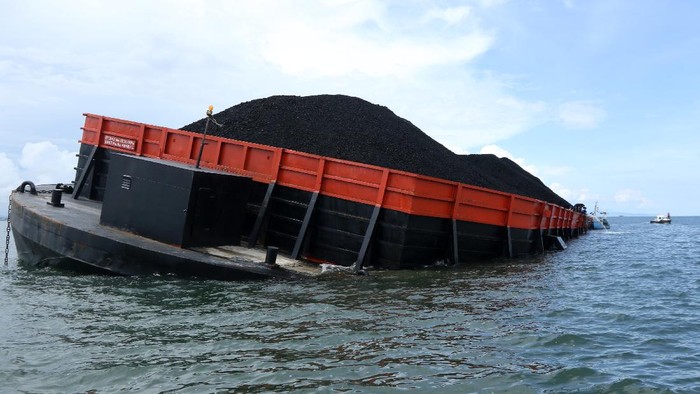 Foto udara kapal tongkang yang mengalami kebocoran di Perairan Sembulungan, Muncar, Banyuwangi,  Jawa Timur, Rabu (10/11/2021). Kapal tongkang Gold Trans 308 bermuatan 7.500 metrik ton batu bara dari Banjarmasin menuju Cilacap itu mengalami kebocoran lambung kiri yang mengakibatkan posisi kapal miring dan menyebabkan sebagian muatan tumpah di zona konservasi Teluk Sembulungan. ANTARA FOTO/Budi Candra Setya/aww.