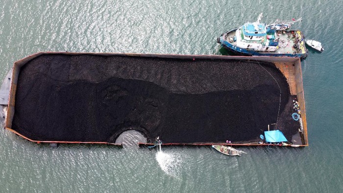 Kapal Tongkang Muatan Batu Bara Karam di Teluk Banyuwangi Foto udara kapal tongkang yang mengalami kebocoran di Perairan Sembulungan, Muncar, Banyuwangi, Jawa Timur, Rabu (10/11/2021). Kapal tongkang Gold Trans 308 bermuatan 7.500 metrik ton batu bara dari Banjarmasin menuju Cilacap itu mengalami kebocoran lambung kiri yang mengakibatkan posisi kapal miring dan menyebabkan sebagian muatan tumpah di zona konservasi Teluk Sembulungan. ANTARA FOTO/Budi Candra Setya/aww.