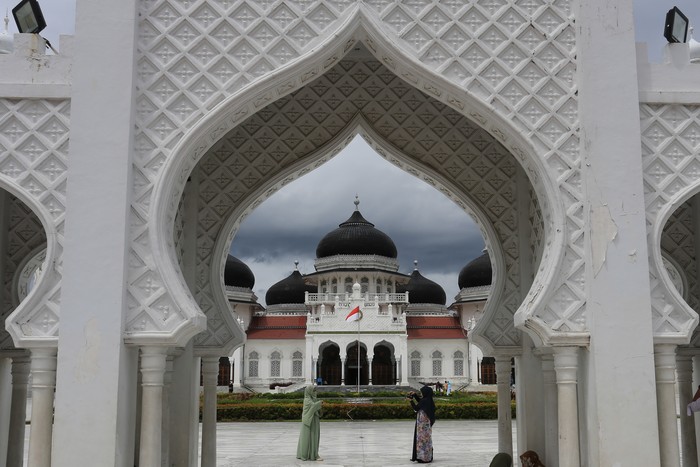 Pengunjung berfoto di kawasan Masjid Raya Baiturrahman, Banda Aceh, Aceh, Rabu (10/11/2021). Masjid Raya Baiturrahman merupakan ikon Provinsi Aceh yang termasuk dalam salah satu masjid tertua dan termegah di Asia yang dibangun abad 16 pada masa Kerajaan Sultan Iskandar Muda yang menjadi objek wisata religi bagi wisatawan domestik dan mancanegara. ANTARA FOTO/Syifa Yulinnas/aww.