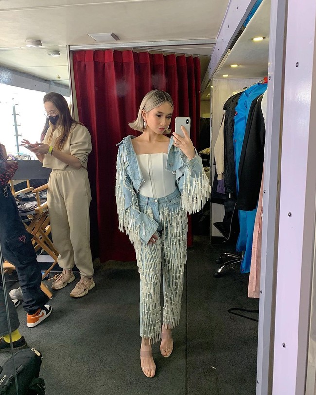 Begini gayanya dengan setelan denim yang dibuat lebih unik karena hadir berumbai. Ia pun mengenakan atasan serupa korset yang menambah sentuhan seksi. Foto: Instagram @nikizefanya