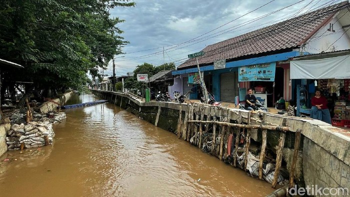 Tanggul Kali Baru di kawasan HEK, Kramat Jati, Jakarta Timur jebol diterjang derasnya air saat hujan melanda kawasan tersebut, Senin (8/11/2021) dini hari.
