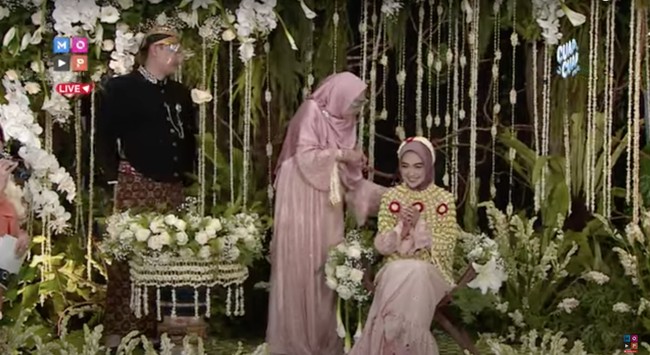 Acara siraman Ria Ricis berlangsung dengan lancar, dimulai dari sang ibu kemudian dilanjutkan dengan beberapa anggota keluarganya yang hadir. Raut wajah bahagia pun terlihat jelas di wajah Ria Ricis. Foto: YouTube/MOP Channel