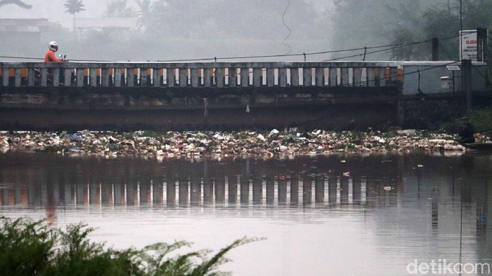 Debit air Sungai Cikeruh meningkat, membuat sampah menumpuk di jembatan sungai yang berada di Kecamatan Bojongsoang, Kabupaten Bandung, Rabu (10/11/2021) pagi.