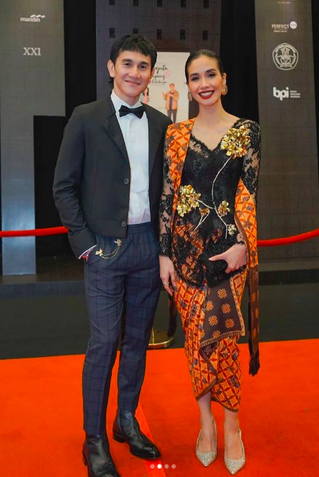 Kebaya bernuansa oranye karya Biyan Wanaatmadja membungkus tubuh aktris Marsha Timothy. Sang aktris datang bersama suaminya, aktor Vino Bastian. (Foto: Instagram/@marsyatimothy/@snap.nuel)