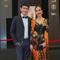 Kebaya bernuansa oranye karya Biyan Wanaatmadja membungkus tubuh aktris Marsha Timothy. Sang aktris datang bersama suaminya, aktor Vino Bastian. (Foto: Instagram/@marsyatimothy/@snap.nuel)