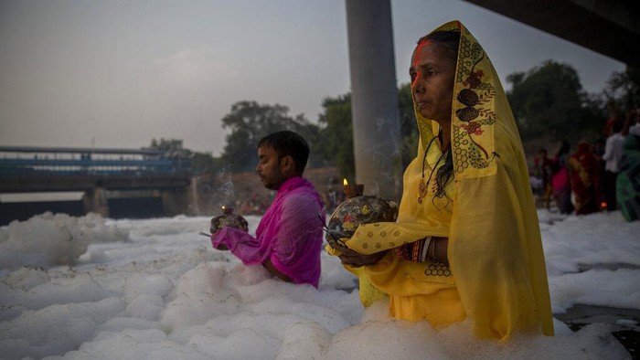 Indian Hindu devotees perform rituals in Yamuna river, covered by chemical foam caused due to industrial and domestic pollution, during Chhath Puja festival in New Delhi, India, Wednesday, Nov. 10, 2021. A vast stretch of one of Indias most sacred rivers, the Yamuna, is covered with toxic foam, caused partly by high pollutants discharged from industries ringing the capital New Delhi. Still, hundreds of Hindu devotees Wednesday stood knee-deep in its frothy, toxic waters, sometimes even immersing themselves in the river for a holy dip, to mark the festival of Chhath Puja. (AP Photo/Altaf Qadri)