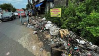 Warga tetap membuang sampah di lokasi ini meski juga terpasang spanduk larangan membuang sampah.