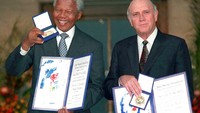 De Kelrk dan Mandela menunjukan nobel perdamaian yang diraih keduanya, Desember 1993.