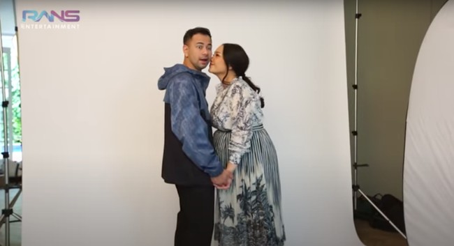 Dalam video sesi pemotretan maternity yang diunggah di channel YouTube Rans Entertainment terlihat Nagita Slavina dan Raffi Ahmad yang kompak berpose mesra. Seperti dalam foto yang satu ini, keduanya tampak bergandengan tangan dengan Nagita yang kemudian mencium pipi Raffi. Foto: YouTube/Rans Entertainment