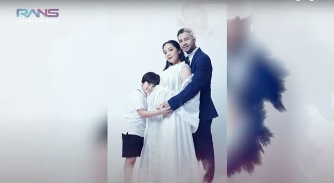 Dalam foto yang satu ini Nagita Slavina terlihat cantik mengenakan gaun panjang berwarna putih. Nagita tampak kompak berpose bersama sang suami dan anak pertamanya. Foto: YouTube/Rans Entertainment