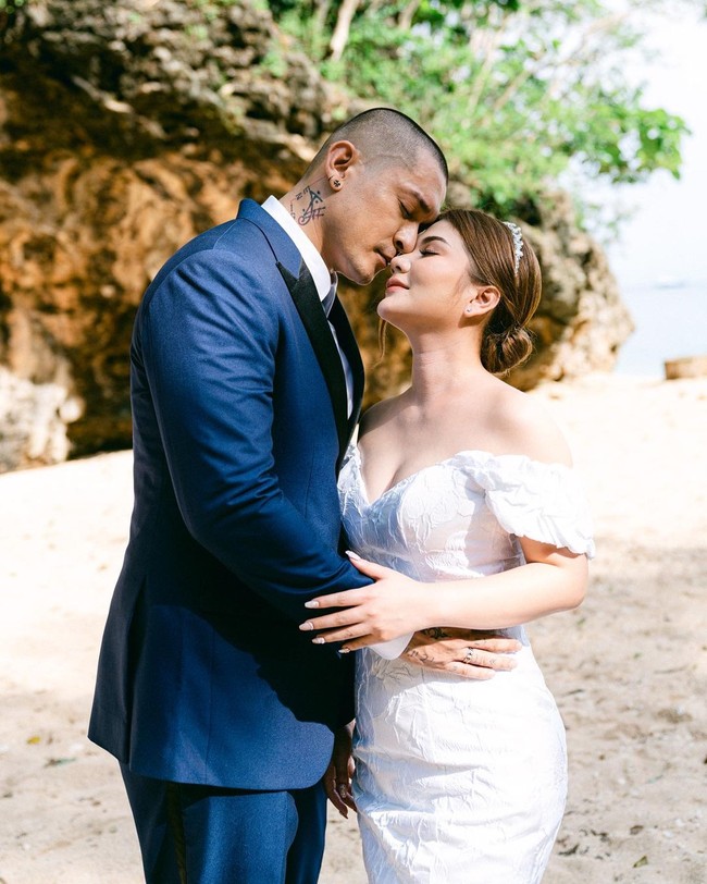 Dalam foto pernikahan yang dibagikan Miller Khan, pria 34 tahun itu mengenakan setelan biru tua sedangkan Farina memakai gaun pengantin putih keluaran Yohannes Bridal. Foto: Instagram @miller_khan