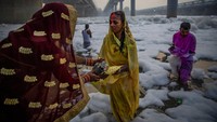 Ritual itu digelar di tengah sungai yang tampak dipenuhi limbah busa berwarna putih. 