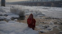 Tampak seorang umat Hindu tengah menggelar ritual di Sungai Yamuna yang dipenuhi busa limbah di kawasan New Delhi, India.