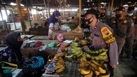 Petugas Satgas COVID-19 berbincang dengan pedagang saat melakukan razia warga yang belum divaksin COVID-19 di Pasar Bandung, Tegal, Jawa Tengah, Kamis (11/11/2021).