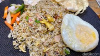 Sedang lapar? Coba pesan Nasi Goreng Kecombrang (Rp 40.000) yang jadi salah satu menu favorit di sini. Tampilannya menggiurkan dengan pelengkap acar, emping, dan telur mata sapi.
