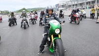 Jaket hitam yang dipakai Jokowi dilengkapi dengan beberapa aksen, termasuk bordir besar di bagian dada dan nomor di sisi kiri depan. Jaket bergaya retro itu tampak selaras dengan motor balap yang dikendarai. Foto: Fotografer Istana Kepresidenan Agus Suparto