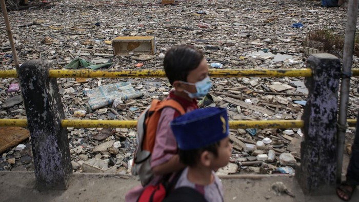 Sejumlah kendaraan melaju di samping sampah yang menumpuk di Kali Dadap yang dipenuhi sampah di Kosambi, Kabupaten Tangerang, Banten, Jumat (12/11/2021). Kali tersebut dipenuhi oleh sampah sehingga menimbulkan bau tak sedap dan berpotensi menyimbulkan penyakit bagi warga sekitarnya. ANTARA FOTO/Fauzan/aww.
