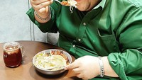 Tampak bergembira, begini momen Rony DOzer saat makan semangkuk soto. Ditemani dengan es teh manis yang segar untuk pelepas dahaga. Foto: Instagram @dozersmile75