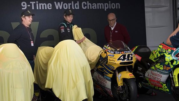 VALENCIA, SPAIN - NOVEMBER 11: Carmelo Ezpeleta (R) of Spain and Dorna CEO  and  Valentino Rossi of Italy and Petronas Yamaha SRT pose near the 9 bikes with which he won the World Championships in paddock during the MotoGP of Comunitat Valenciana: Previews at Ricardo Tormo Circuit on November 11, 2021 in Valencia, Spain. (Photo by Mirco Lazzari gp/Getty Images)