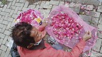 Para pedagang yang berjajar di tepi jalan, menjual bunga tabur dengan harga Rp 5.000 per plastik. 