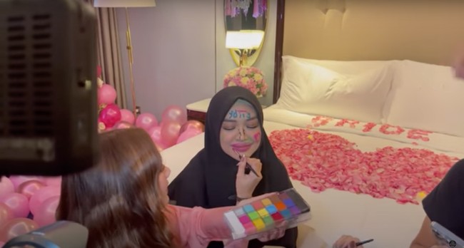 Sama seperti acara bridal shower pada umumnya, wajah Ria Ricis pun terlihat dicorat-coret oleh para sahabatnya. Dimulai dari Teuku Ryan terlebih dahulu, lalu dilanjutkan oleh para sahabatnya yang dengan semangat memberikan coretan warna-warni di wajah Ricis. Foto: YouTube/Tri Atika