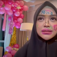 Ria Ricis pun hanya bisa terlihat pasrah wajahnya dicorat-coret oleh para sahabat. Dan begini hasil dari coretan para sahabat di wajah Ricis. Foto: YouTube/Tri Atika