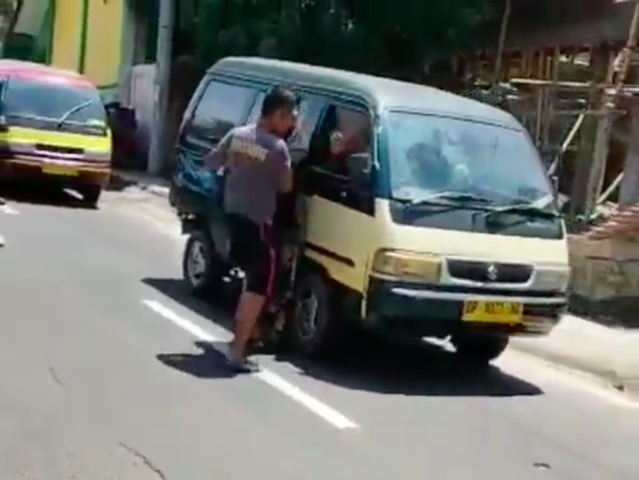 Video pria berkaus bertuliskan Brimob beradu argumen dengan seorang sopir dan memukul angkot viral di medsos. Begini ceritanya. (Screenshot video viral)