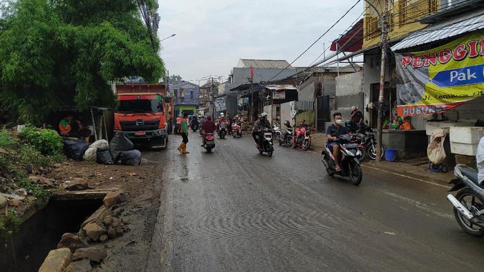 Banjir di Jalan Kemang Utara IX, Jakarta Selatan, arah Pasar Kemang, sudah surut, Sabtu (13/11/2021). Petugas kebersihan tampak membersihkan jalanan dari lumpur hingga sampah.
