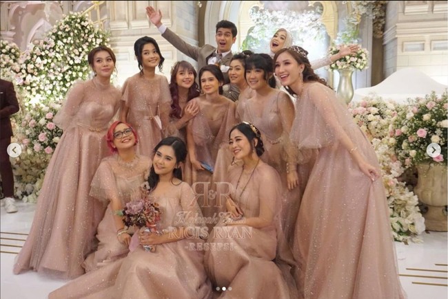 Begini potret Ria Ricis dan Teuku Ryan bersama para bridesmaid. Raut wajah bahagia pun tergambar jelas di wajah pasangan pengantin baru tersebut. Foto: Instagram/@officialmnctv