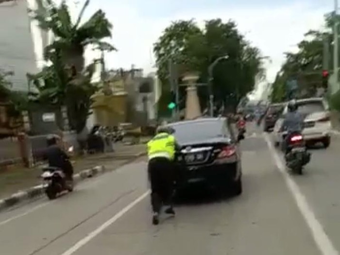 Sebuah video yang menunjukkan personel polantas mendorong mobil di jalanan Medan, Sumut beredar di medsos. Mobil itu disebut dalam keadaan mogok. (dok Istimewa)