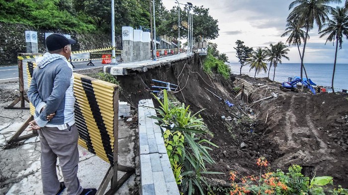 TEBING LONGSOR DI JALUR WISATA SENGGIGI Warga berdiri dekat tebing jalan yang longsor di kawasan wisata Senggigi, Kecamatan Batulayar, Lombok Barat, NTB, Sabtu (13/11/2021). Longsor yang terjadi pada Kamis (11/11) malam saat hujan lebat tersebut menyebabkan jalan wisata Senggigi amblas sepanjang sekitar 25 meter dengan kedalaman 10 meter. ANTARA FOTO/Ahmad Subaidi/aww.