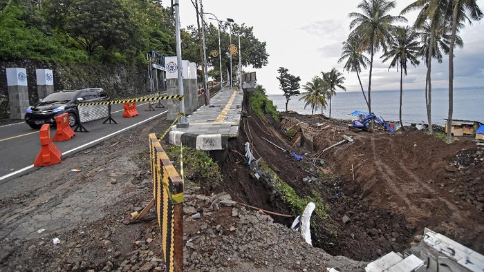 Warga berdiri dekat tebing jalan yang longsor di kawasan wisata Senggigi, Kecamatan Batulayar, Lombok Barat, NTB, Sabtu (13/11/2021). Longsor yang terjadi pada Kamis (11/11) malam saat hujan lebat tersebut menyebabkan jalan wisata Senggigi amblas sepanjang sekitar 25 meter dengan kedalaman 10 meter. ANTARA FOTO/Ahmad Subaidi/aww.