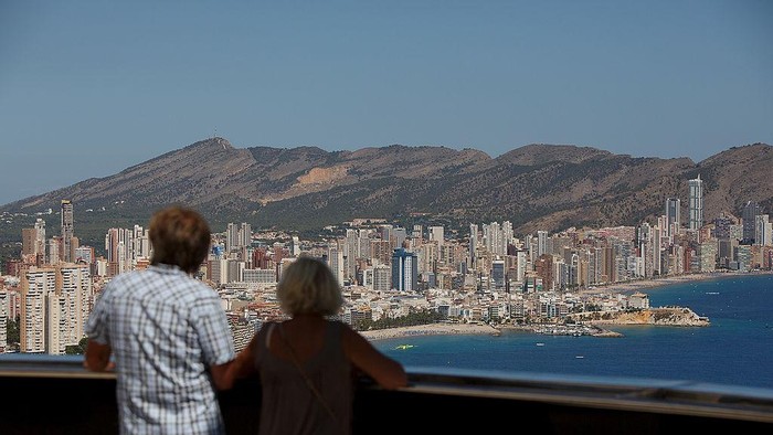 People look at the city and beach from the Gran Hotel Balis balcony on August 9, 2013 in Benidorm, Spain. Benidorm is one of Europes top package holiday destinations and one of Spains busiest tourist destinations. The Costa Blanca hotspot of Benidorm is calculated to have a population of around 72,000, which is estimated to rise to more than 300,000, during the summer months as the tourists and visitors flock to its popular beaches.  (Photo by Pablo Blazquez Dominguez/Getty Images)