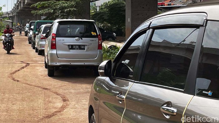 Puluhan mobil terparkir di kolong Tol Becakayu, Jakarta. Mobil milik warga Cipinang Melayu yang khawatir banjir menerjang tempat tinggal mereka.