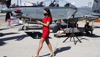Seorang wanita berjalan di saat para kru mempersiapkan pesawat yang akan ditampilkan di Dubai Air Show.