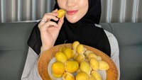 Henny, sosok yang cukup aktif di media sosial. Ia sering membagikan momen kulinernya, salah satunya menikmati kurma muda. Foto: Instagram @hennyrahman