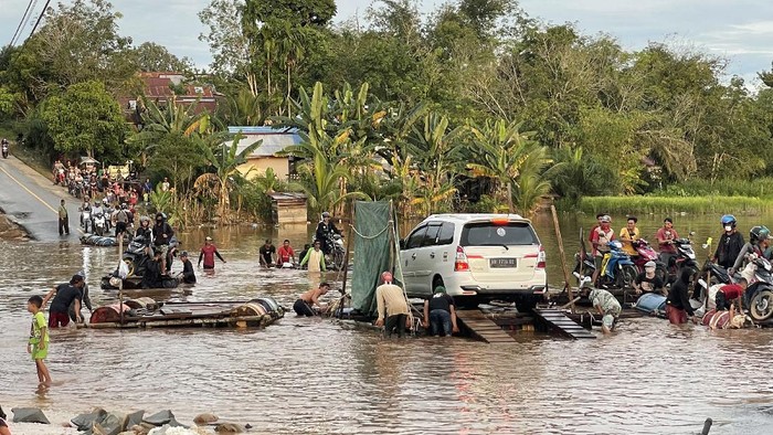 Sejumlah warga dan kendaraan memadati ruas jalan Sintang-Putussibau yang putus akibat terendam banjir di Kabupaten Sintang, Kalimantan Barat, Sabtu (13/11/2021). BPBD Kabupaten Sintang menyatakan banjir masih merendam beberapa kecamatan di daerah setempat, meski demikian banjir telah surut 10 hingga 15 sentimeter pada Jumat (12/11/2021) kemarin. ANTARA FOTO/Jane Elisabeth Wuysang/jhw/wsj.