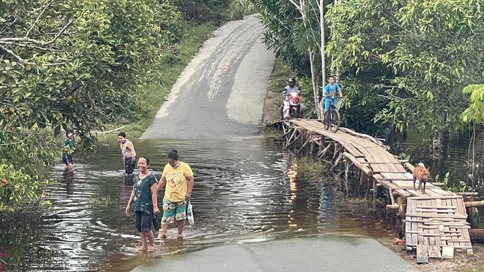 Jadi Bahan Fadli Zon Sindir Jokowi, Begini Kondisi Banjir Sintang Sejumlah warga dan kendaraan memadati ruas jalan Sintang-Putussibau yang putus akibat terendam banjir di Kabupaten Sintang, Kalimantan Barat, Sabtu (13/11/2021). BPBD Kabupaten Sintang menyatakan banjir masih merendam beberapa kecamatan di daerah setempat, meski demikian banjir telah surut 10 hingga 15 sentimeter pada Jumat (12/11/2021) kemarin. ANTARA FOTO/Jane Elisabeth Wuysang/jhw/wsj.